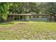 The home's back exterior has a large yard with mature trees and partial fencing at 34577 Orchid Pkwy, Dade City, FL 33523