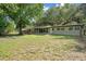 The home's back exterior has a large yard with mature trees and partial fencing at 34577 Orchid Pkwy, Dade City, FL 33523