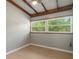 The bedroom features light grey walls, updated flooring, and a window overlooking the yard at 34577 Orchid Pkwy, Dade City, FL 33523