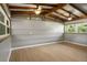The bonus room has wood beam ceilings, plank walls, updated flooring, and large windows at 34577 Orchid Pkwy, Dade City, FL 33523
