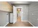 Hallway featuring utility hook-ups and a white door leading into the modern kitchen at 34577 Orchid Pkwy, Dade City, FL 33523