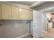 Hallway featuring utility hook-ups and a white door leading into the modern kitchen at 34577 Orchid Pkwy, Dade City, FL 33523