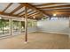 Bright living room featuring wood-beam ceiling, updated floors, and sliding glass doors to connect the indoors with the outdoors at 34577 Orchid Pkwy, Dade City, FL 33523