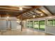 Open-concept living area with a wood-beam ceiling, modern floors, and access to the kitchen and the outdoors at 34577 Orchid Pkwy, Dade City, FL 33523