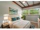 Comfortable bedroom featuring a large window with view to nature, and wood ceiling beams at 34577 Orchid Pkwy, Dade City, FL 33523