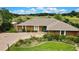 Aerial view of home with a large driveway, attached garage and landscaping with natural greenery backdrop at 364 Waterfall Dr, Spring Hill, FL 34608