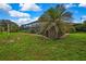 Expansive backyard featuring a palm tree and screened-in pool area at 364 Waterfall Dr, Spring Hill, FL 34608