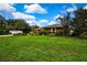 Landscaped yard of home with mature trees and flowers; white fence on left side of image adds privacy at 364 Waterfall Dr, Spring Hill, FL 34608