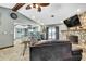 Bright living area showcasing the stone fireplace, ceiling fan, and a view to the kitchen at 364 Waterfall Dr, Spring Hill, FL 34608