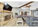Comfortable living room with a stone fireplace, modern lighting, and tiled flooring at 364 Waterfall Dr, Spring Hill, FL 34608