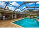 Backyard oasis featuring a screened-in pool, brick patio, and covered seating at 364 Waterfall Dr, Spring Hill, FL 34608
