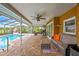 Inviting pool area with brick paving, screened enclosure, fan, and ample seating at 364 Waterfall Dr, Spring Hill, FL 34608