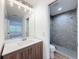 Bright bathroom vanity with modern lighting and walk-in shower with gray tile surround at 3712 Trophy Blvd # 3712, New Port Richey, FL 34655