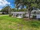 Exterior view of charming home with a well-maintained lawn and mature tree at 3712 Trophy Blvd # 3712, New Port Richey, FL 34655