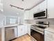 Well-lit kitchen features stainless steel appliances, white cabinets, and sleek countertops at 3712 Trophy Blvd # 3712, New Port Richey, FL 34655