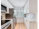 Galley kitchen featuring stainless steel appliances, white cabinets, and natural light at 3712 Trophy Blvd # 3712, New Port Richey, FL 34655