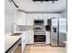 Bright kitchen with stainless steel appliances, white cabinetry and gray backsplash at 3712 Trophy Blvd # 3712, New Port Richey, FL 34655