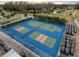 Aerial view of the tennis and pickleball courts near a pond and lined with golf carts at 3712 Trophy Blvd # 3712, New Port Richey, FL 34655