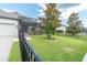 Well-maintained backyard featuring a screened-in lanai, manicured lawn, and black fencing for outdoor enjoyment at 3885 Villamore Ln, Odessa, FL 33556