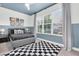 Stylish bedroom featuring blue color scheme, natural light, and a playful rug at 3885 Villamore Ln, Odessa, FL 33556