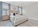 Comfortable bedroom with elegant chandelier, wallpaper accent, and large windows at 3885 Villamore Ln, Odessa, FL 33556