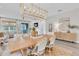 Elegant dining area connected to the living room with a modern chandelier, stylish furniture, and serene decor at 3885 Villamore Ln, Odessa, FL 33556