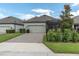 Home exterior featuring a paved driveway, two-car garage, screened-in porch, and manicured lawn at 3885 Villamore Ln, Odessa, FL 33556