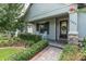 Inviting home exterior showcasing a covered front porch, stone accents, and lush landscaping for curb appeal at 3885 Villamore Ln, Odessa, FL 33556