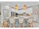 Modern kitchen featuring a spacious island with seating, pendant lighting, and sleek white cabinetry at 3885 Villamore Ln, Odessa, FL 33556