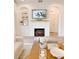 Cozy living room featuring a fireplace with mantel, built-in shelves, and neutral-toned furnishings at 3885 Villamore Ln, Odessa, FL 33556