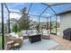 Enjoy outdoor living on this screened patio with wicker furniture and a view of the landscaped backyard at 3885 Villamore Ln, Odessa, FL 33556