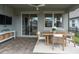 Relax on this covered patio with an outdoor dining table, perfect for enjoying meals and entertaining guests at 3885 Villamore Ln, Odessa, FL 33556