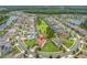 An aerial view of a home in a landscaped neighborhood with a pond and many other homes nearby at 4026 Bonfire Dr, Odessa, FL 33556