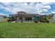 Spacious backyard featuring a screened-in patio, swimming pool, and plenty of green space for outdoor activities at 4026 Bonfire Dr, Odessa, FL 33556