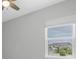 Well-lit bedroom with ceiling fan and window view of neighborhood houses at 4026 Bonfire Dr, Odessa, FL 33556