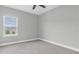 Neutral bedroom featuring carpet, ceiling fan, base molding and a window with neighborhood views at 4026 Bonfire Dr, Odessa, FL 33556