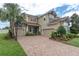 A two-story home with a well-manicured lawn and a brick driveway leading up to the two-car garage at 4026 Bonfire Dr, Odessa, FL 33556