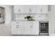 Modern kitchen with custom white cabinets, quartz countertops, and beverage fridge at 4026 Bonfire Dr, Odessa, FL 33556