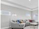 Modern living room featuring a gray sectional sofa and tray ceiling at 4026 Bonfire Dr, Odessa, FL 33556