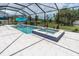 Beautiful pool, spa, and screened-in patio area featuring comfortable outdoor seating and lush backyard views at 4026 Bonfire Dr, Odessa, FL 33556