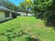 Large back yard with mature trees and shrubs with partially fenced yard at 4420 Sawgrass Blvd, New Port Richey, FL 34653