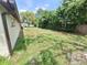 Large back yard with mature trees and partial fence on right at 4420 Sawgrass Blvd, New Port Richey, FL 34653