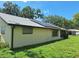 Home featuring a solar panels, a screened-in patio, and spacious yard at 4420 Sawgrass Blvd, New Port Richey, FL 34653