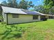 A view of the back of the house showing the backyard and solar panels on the roof at 4420 Sawgrass Blvd, New Port Richey, FL 34653