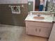 Bathroom featuring a sink with decorative mirror, green tile, and unique wallpaper at 4420 Sawgrass Blvd, New Port Richey, FL 34653
