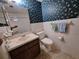 Cozy bathroom featuring a vanity, toilet, decorative wallpaper, and tiled flooring at 4420 Sawgrass Blvd, New Port Richey, FL 34653
