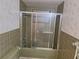 Bathroom showcasing a shower/tub with sliding doors and tiled walls at 4420 Sawgrass Blvd, New Port Richey, FL 34653