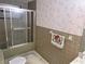 Bathroom featuring a shower/tub with sliding doors, green tile, and vintage wallpaper at 4420 Sawgrass Blvd, New Port Richey, FL 34653
