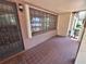 A close up view of the tiled front porch and front door with security screen at 4420 Sawgrass Blvd, New Port Richey, FL 34653