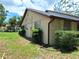 Back of house with manicured shrubs and grass lawn at 4420 Sawgrass Blvd, New Port Richey, FL 34653